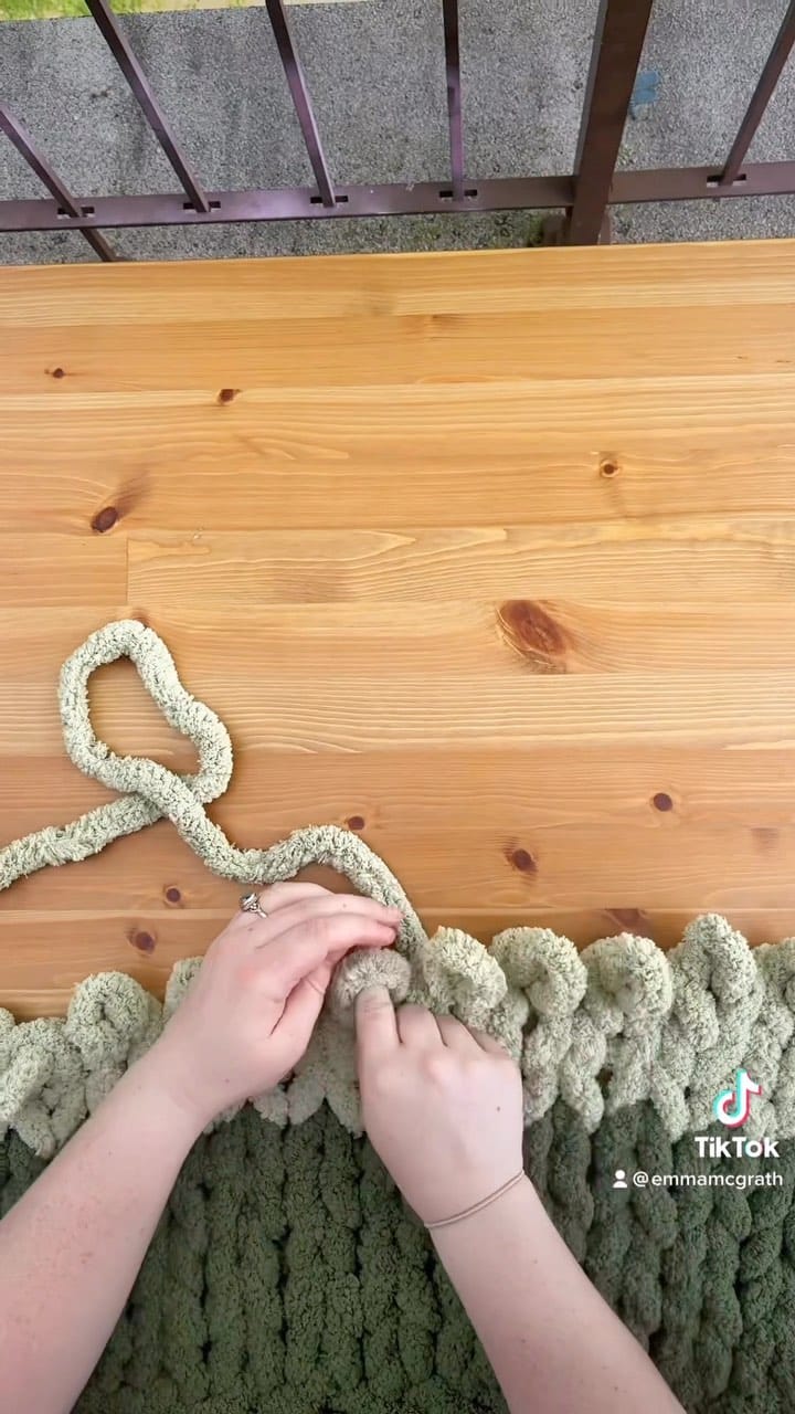 colorful yarn wall hanging on wooden dowel