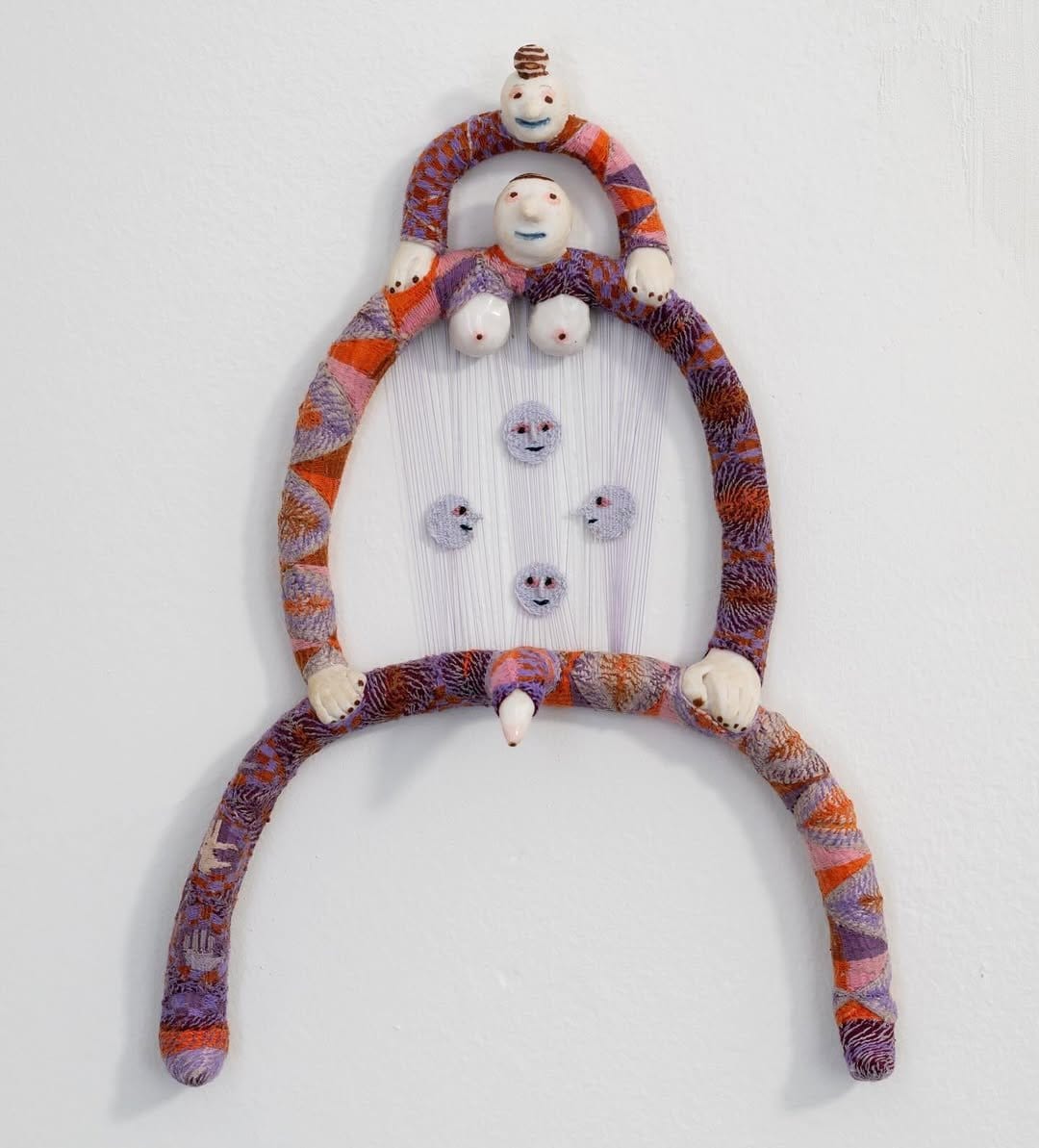 Vibrant handmade woven wall art with pom-poms