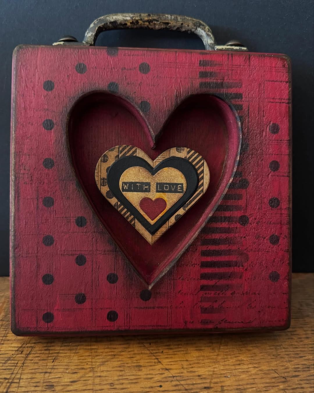 Heart-shaped string art on wooden board