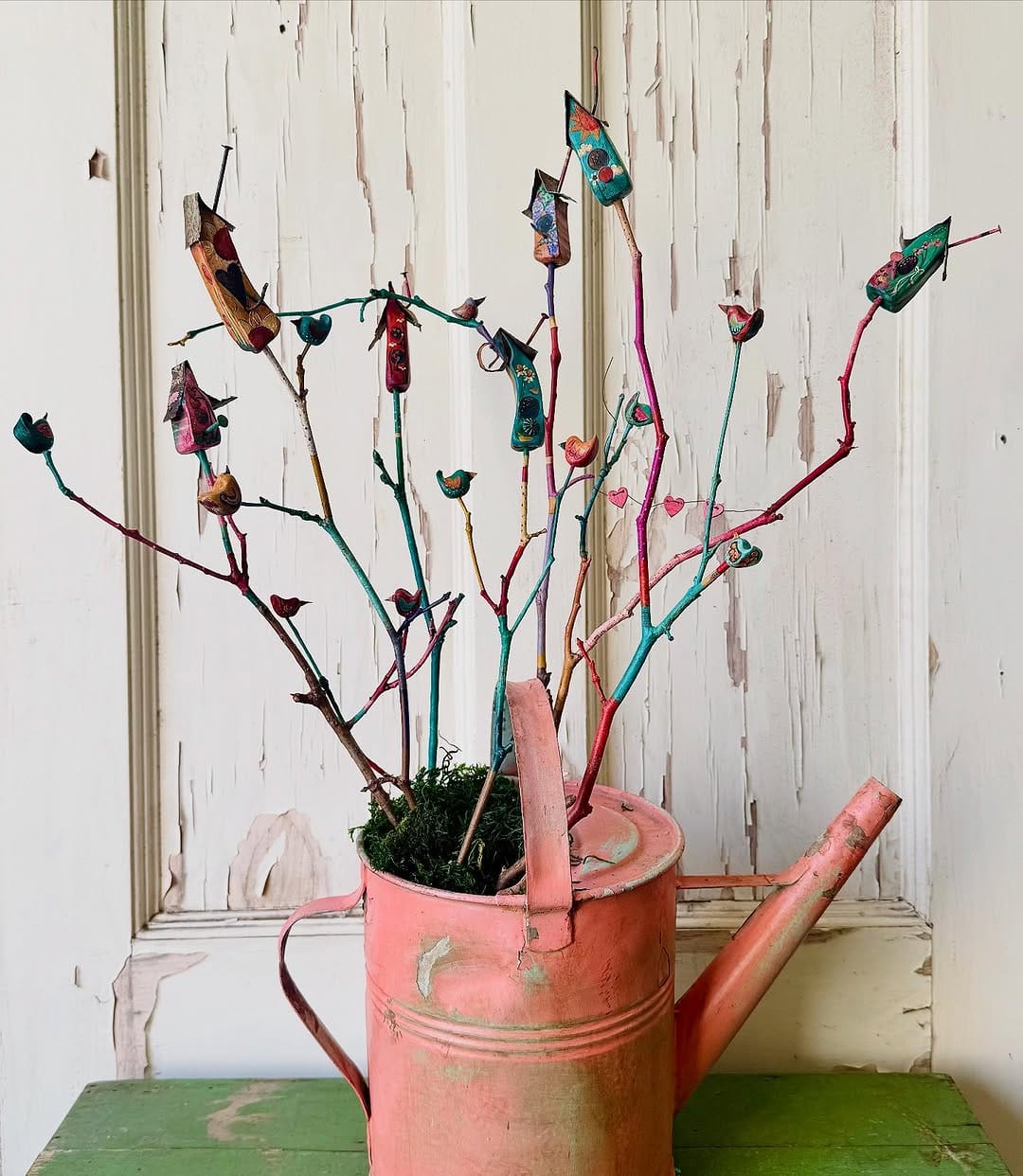 colorful handmade birdhouses hanging in a garden